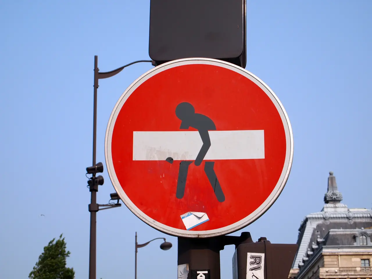 In this image we can see a board to a pole with some text and a picture on it. On the backside we...