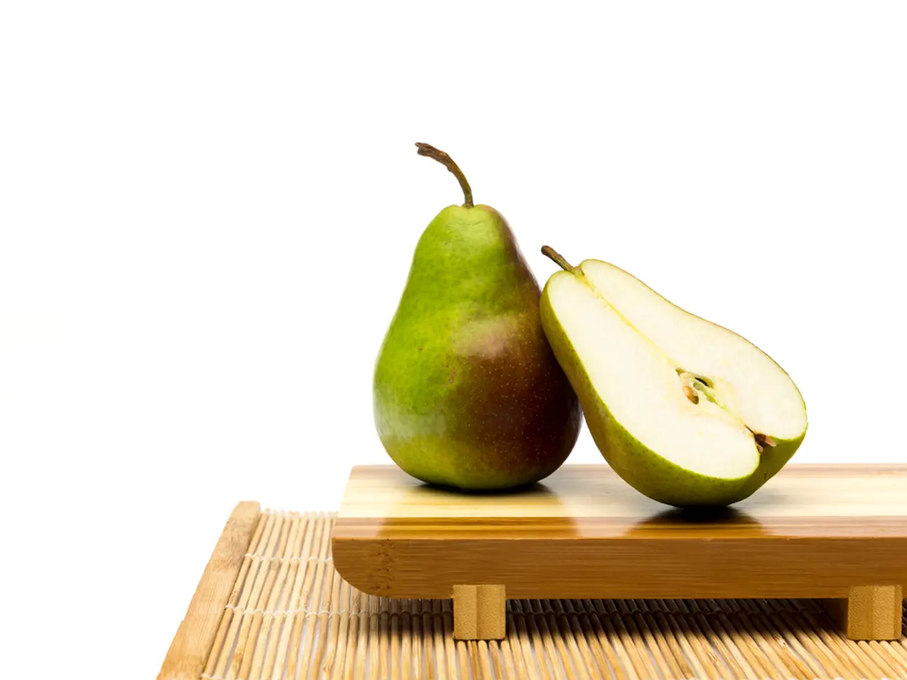 In this image we can see pears placed on the tray. At the bottom there is a mat.