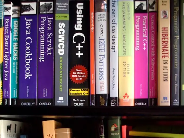 In this image I can see many books in the rack. I can see something is written on these books.