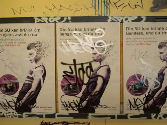 In this image, we can see posters and there is some text on the wall.